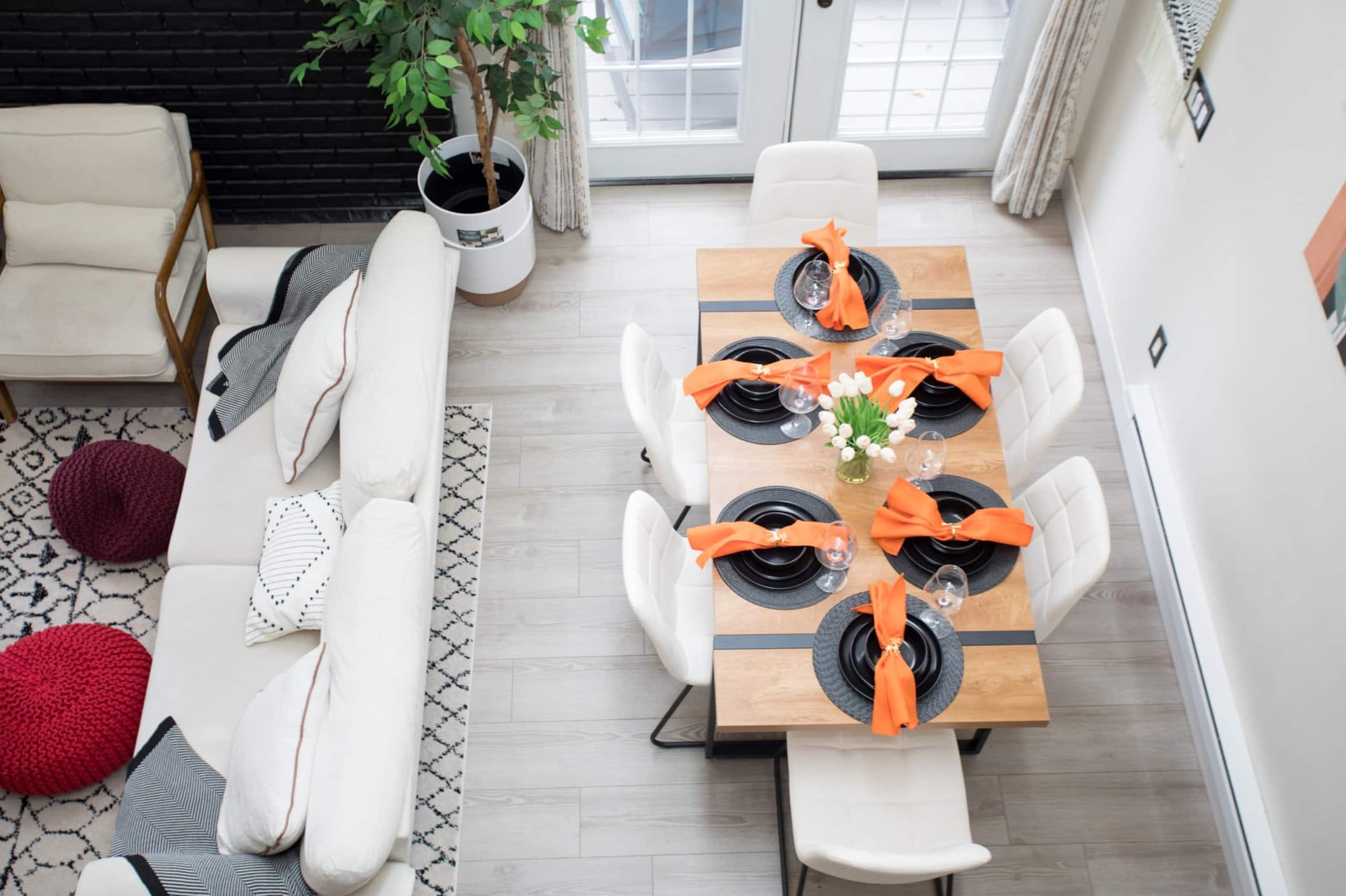 Overhead view of the dining table set for six beside the living-room sofa