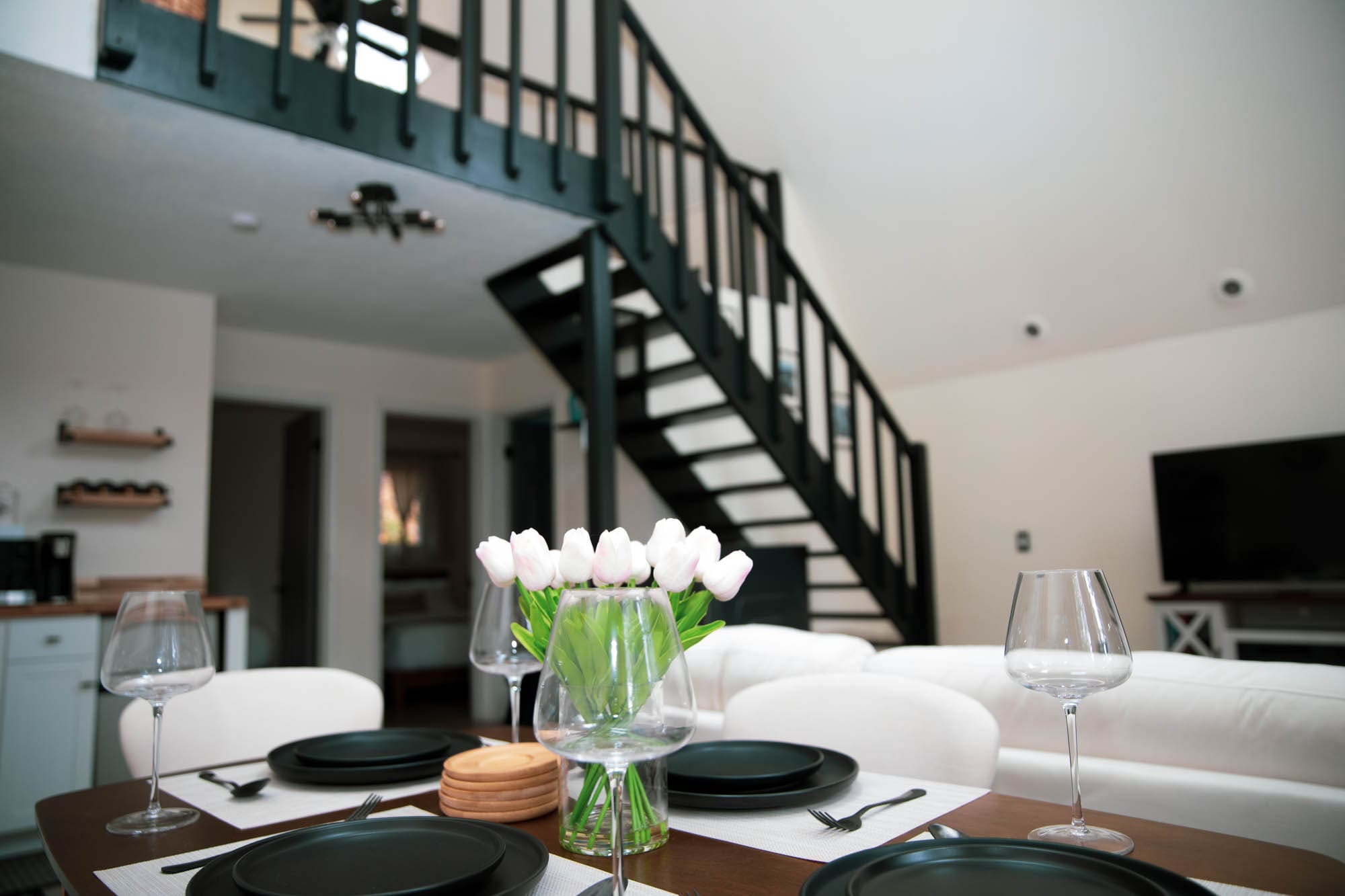 Open living and dining area with the staircase leading up to the A-Frame loft
