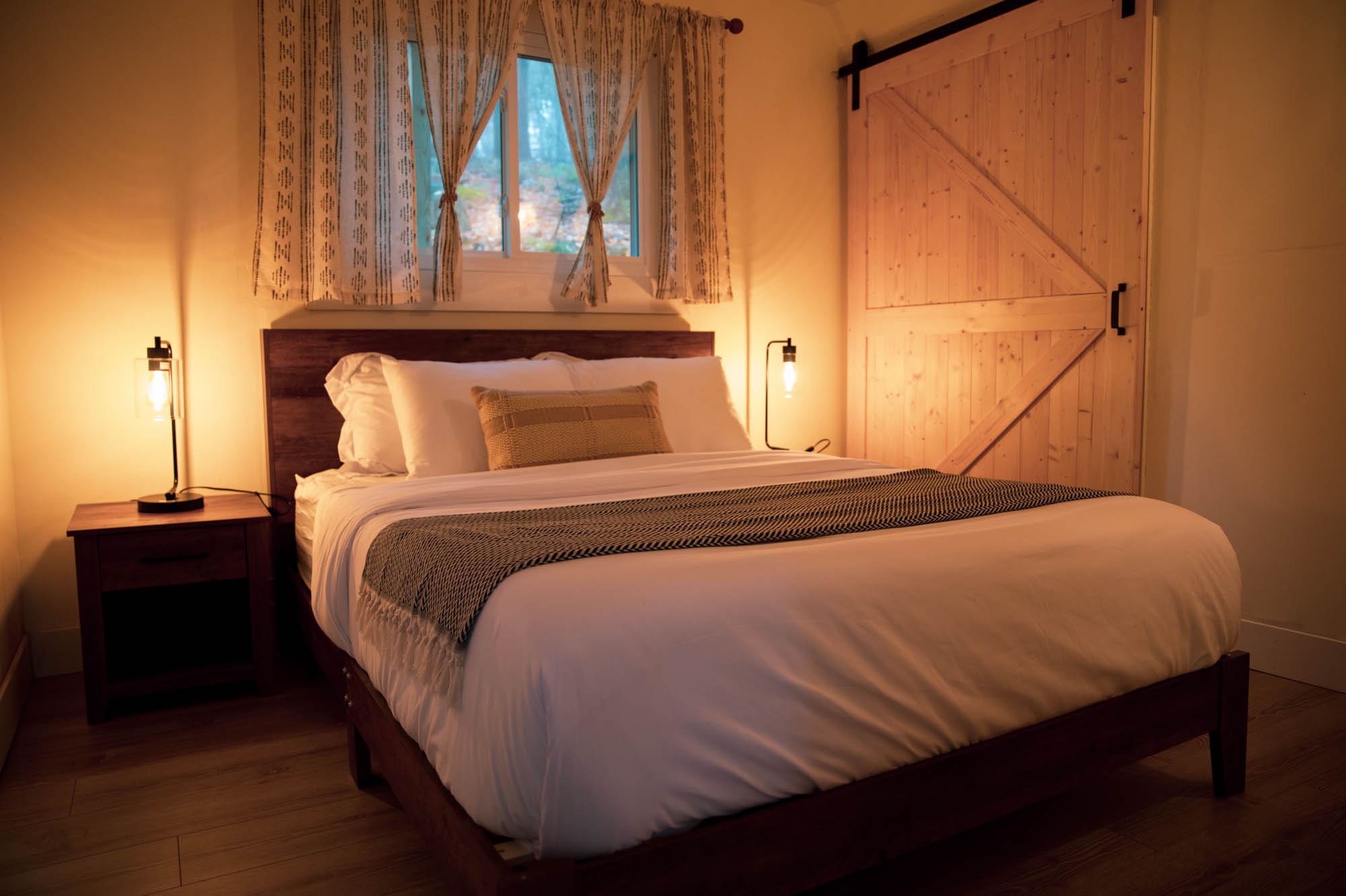 Queen bedroom featuring a rustic wood headboard and barn-style sliding door